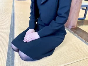 喪服に黒いストッキングで葬儀に参列する女性の画像