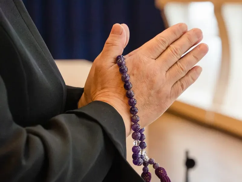 通夜で手を合わせる男性の手元の画像