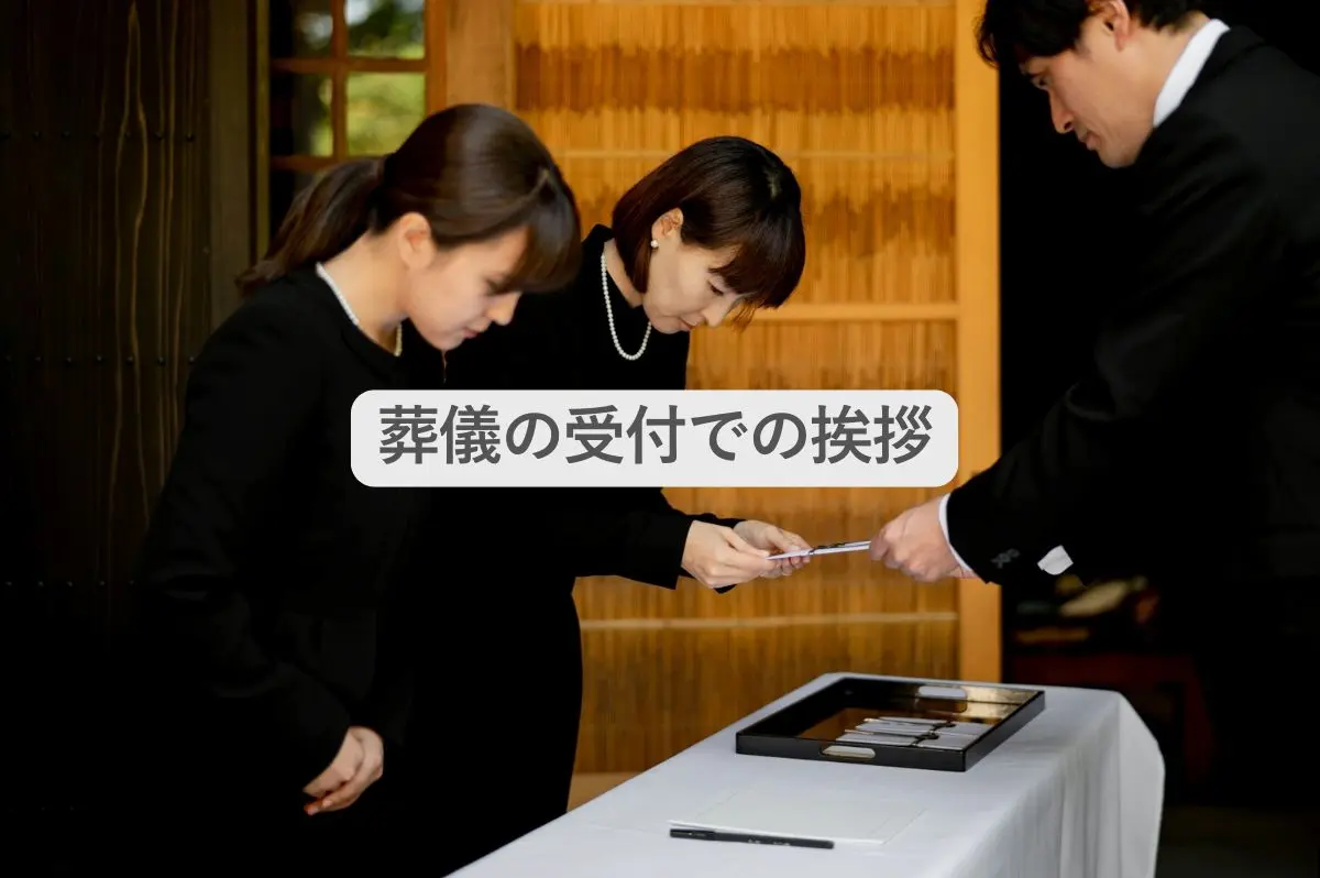 葬儀の受付で挨拶をする男性と参列者の女性